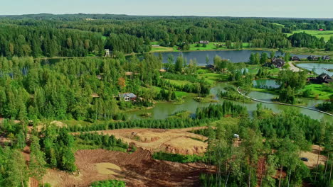 aerial view pan of construction diggers amongst forested trees