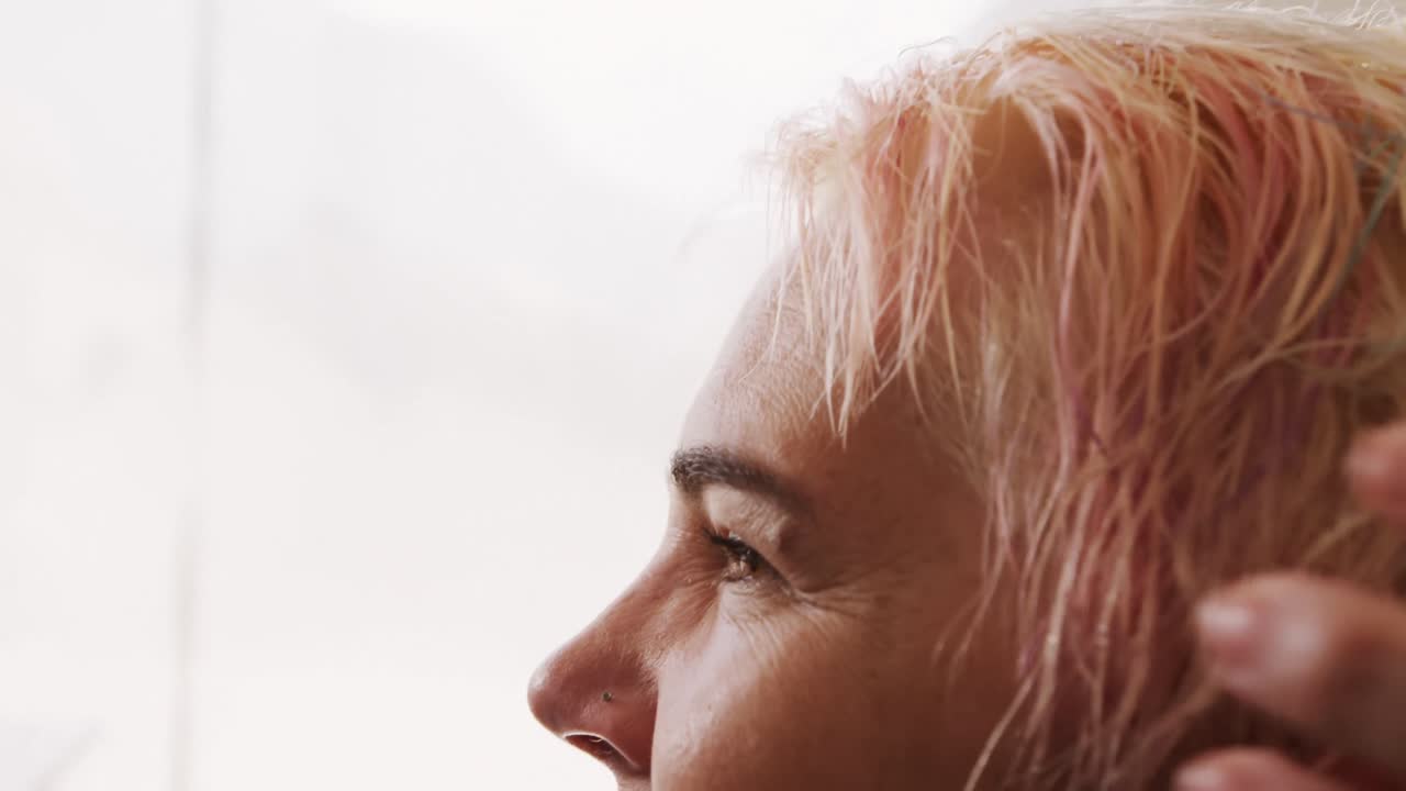 사이드 뷰 여성 이 헤어 드라이 를 하고 있다