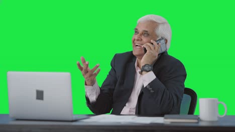 happy indian senior manager talking on mobile phone green screen