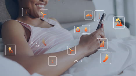 animation of ecology icons and data over biracial woman using smartphone in bed