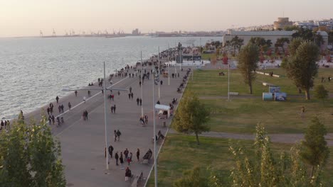 aerial - seaside walkway of thessaloniki with people walking at dusk