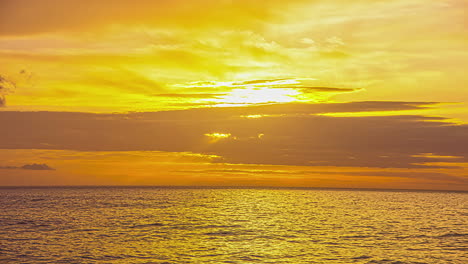 static view of sun setting behind the clouds over the sea along the shoreline in via molino, italy in the evening timelapse