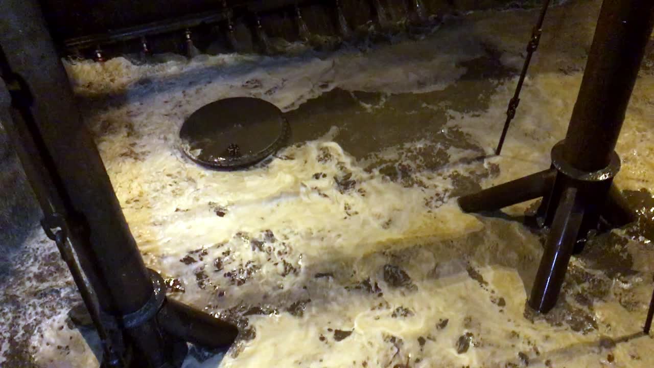 Slowmotion-optagelse af vand, der fylder en muddertank om natten