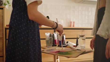 mujeres jóvenes pintando juntas en casa