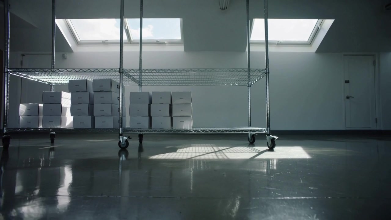 Shifting skylight beam making chrome cart and white boxes casting glow in storage room