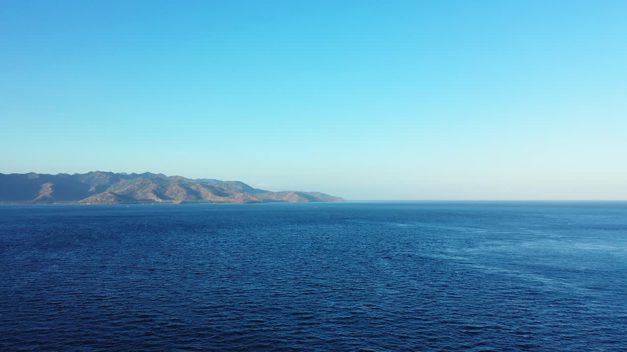 Peaceful seascape with wide blue sea and mountains of tropical islands in Indonesia under bright clear sky