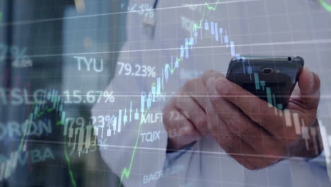 man holding smartphone viewing finance charts in office, overlaying candlestick bars and tickers