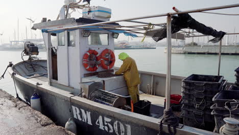 pescador que procesa mariscos en un barco en el puerto