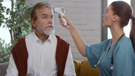 nurse taking temperature of elderly patient