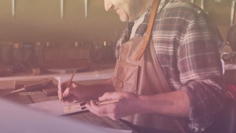 animation of caucasian male worker drawing in workshop