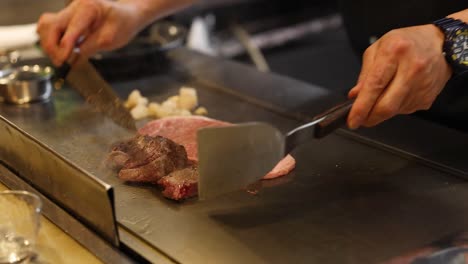 chef skillfully grills steak and vegetables on hotplate