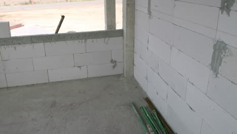 panorámica del marco que muestra algunos bloques apilados uno encima del otro y revela una habitación en construcción dentro de un edificio