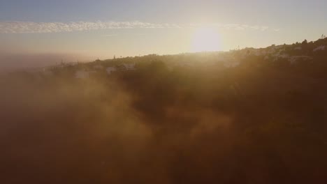 Fog-coming-in-from-the-Atlantic-ocean-during-sunset-at-Luz,-Algarve,-Portugal