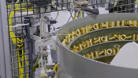 worker putting fittings in a bolt feeder machine in a factory