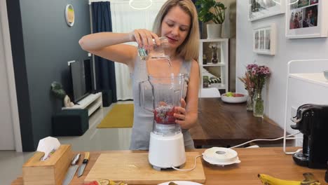 woman making a fruit smoothie