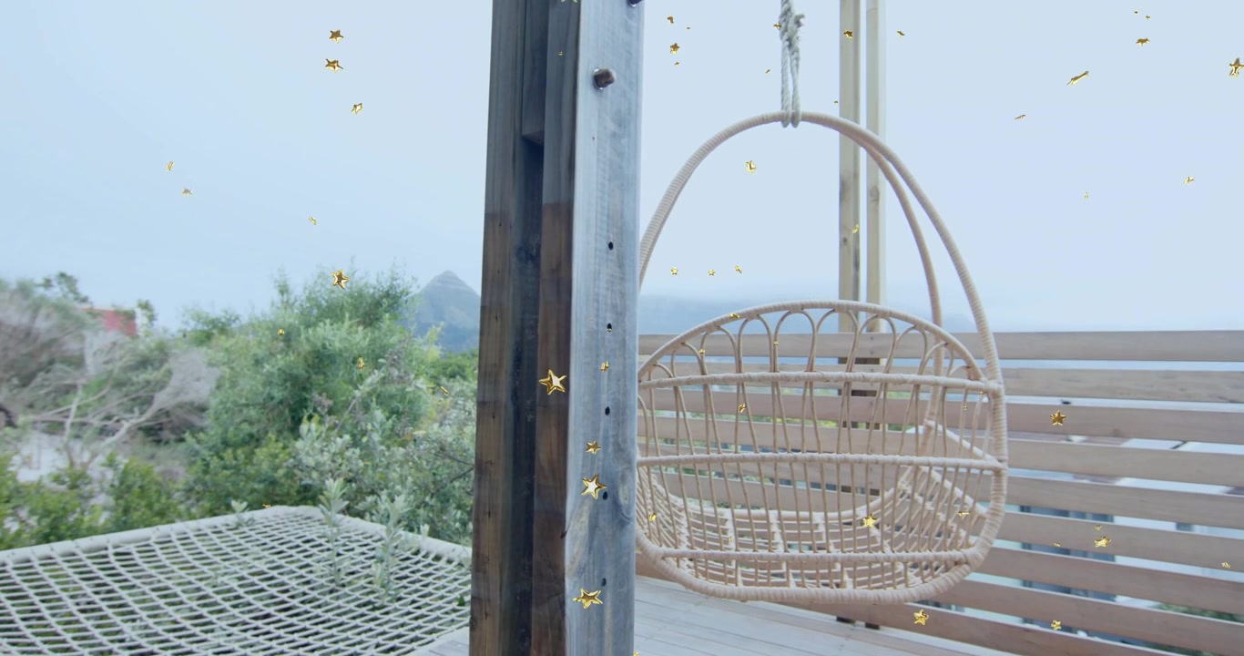 Opening shot showing wicker seat while camera panning revealing support post, hammock and deck view