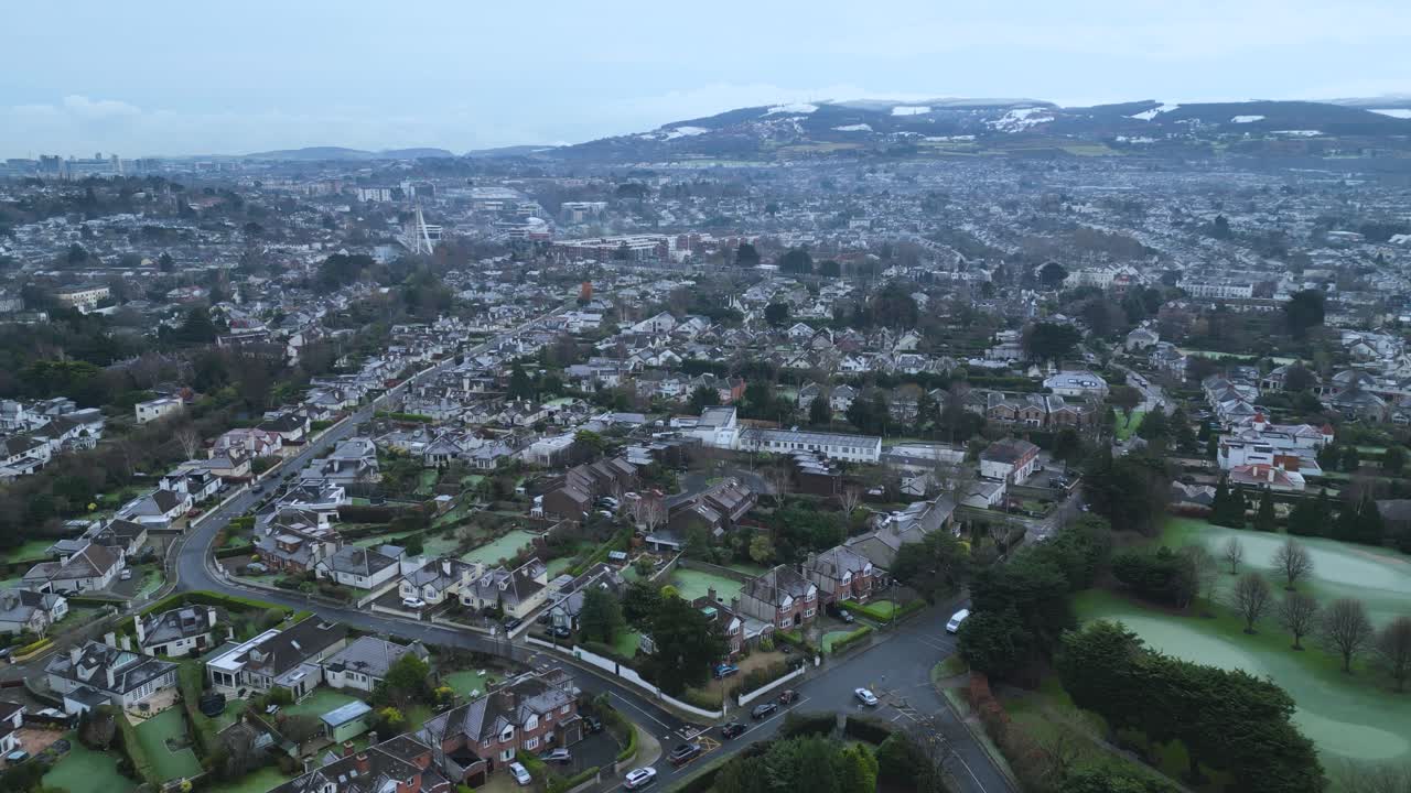 Dolly reverse aerial view of a junction in South Dublin - Churchtown lower road with Orwell Road surrounded by Milltown Golf Club