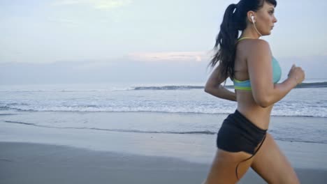 mujer en forma corriendo por la playa