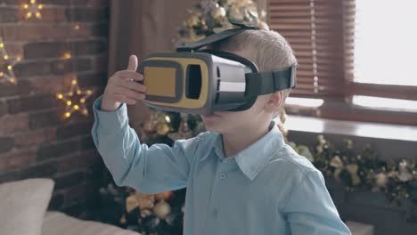 adorable boy kid in blue shirt plays with vr headset