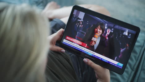 woman watching live news on a tablet