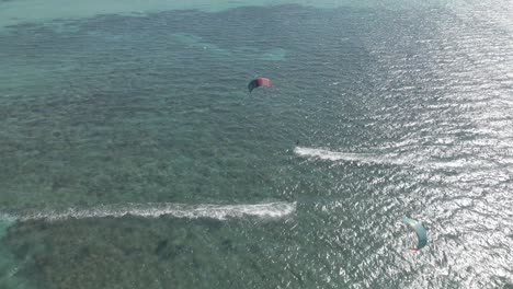 kitesurfer sailing fast behind there kite in the pacific ocean near exmouth australia on a bright sunny windy day