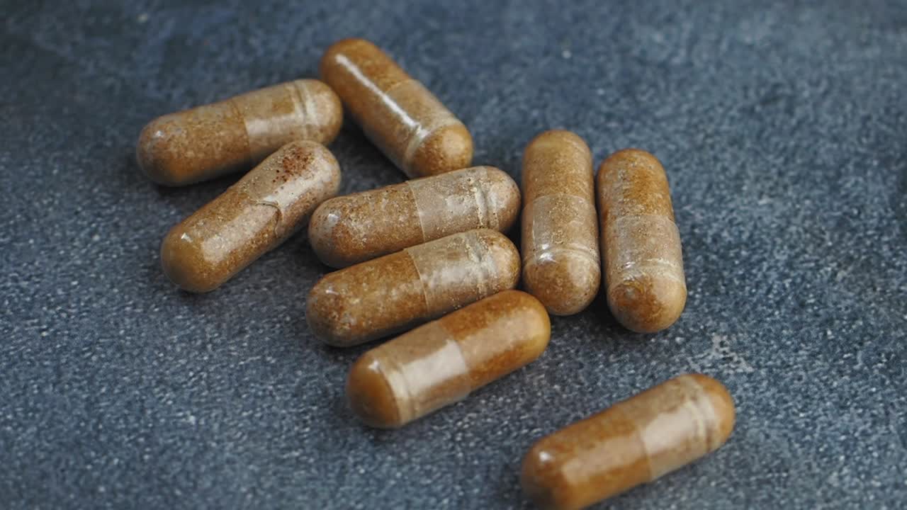Brown Capsules on a Dark Surface