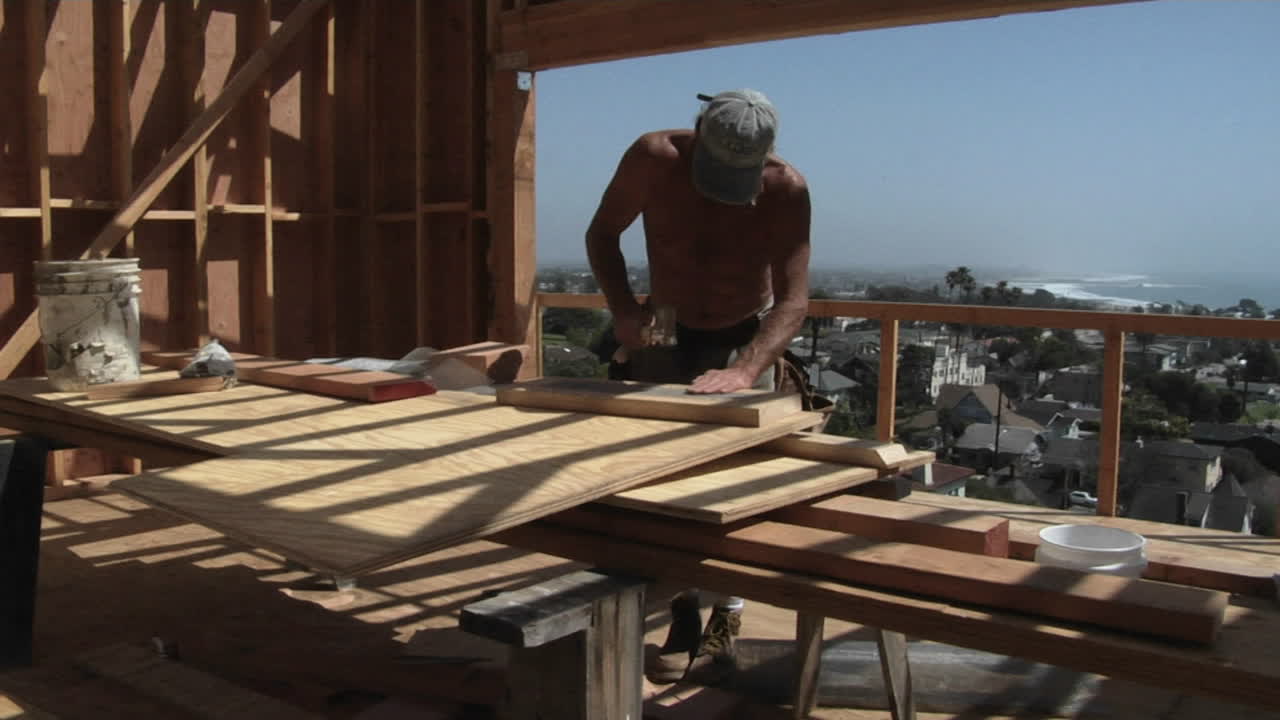 un contratista golpea un trozo de madera y se lo lleva