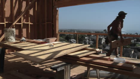 a contractor hammers on a piece of wood and carries it away