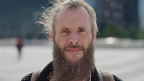 retrato de un hombre hippie barbudo maduro sonriendo, feliz, confiado, disfrutando del estilo de vida urbano despreocupado en la ciudad, con un anillo en la nariz