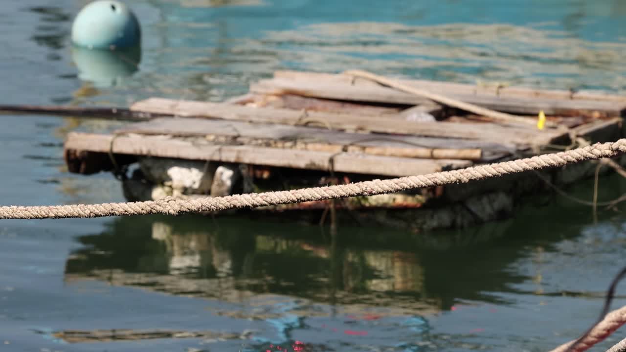 Wooden rafts and boats tied up at a pier