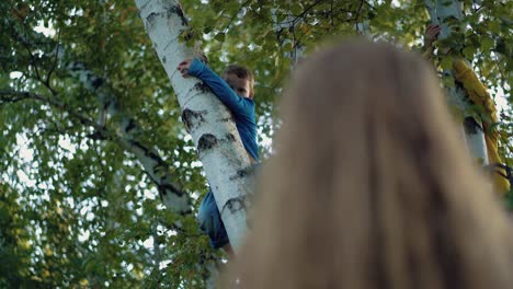 mom looks at his children who are climbing trees