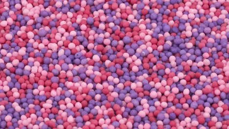 macro shooting of small red, rose and blue sprinkles sugar candies rotating.