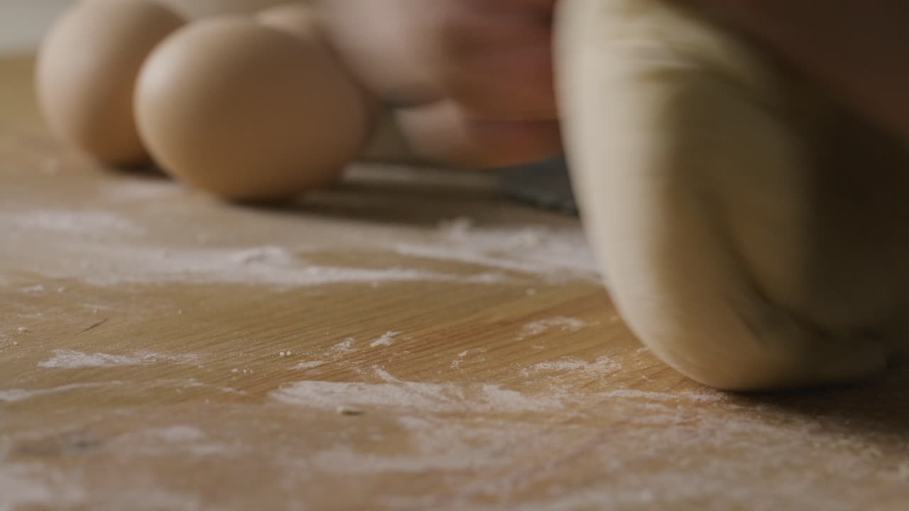 Close-Up of Hands Kneading Dough on Flour-Covered Kitchen Table