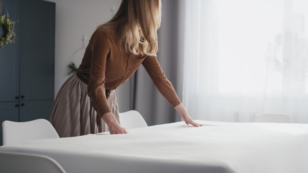 кавказская женщина, лежащая за столом с белой скатертью.