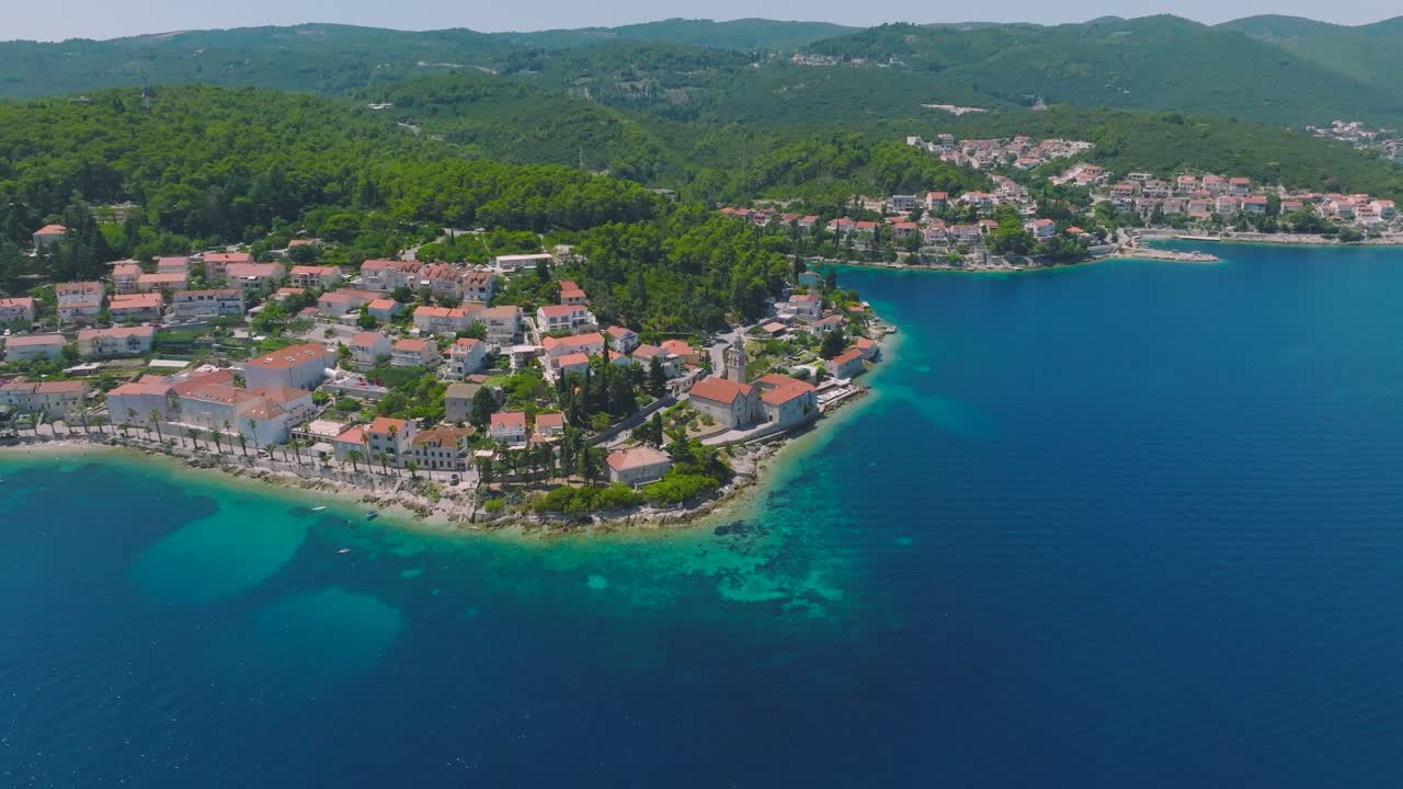 Aerial dolly shot pulling up on a village on the island of Korcula, Croatia on a bright day
