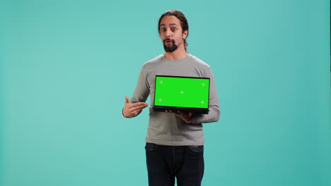 creador de contenido tecnológico que hace marketing de influencia usando una computadora portátil de pantalla verde