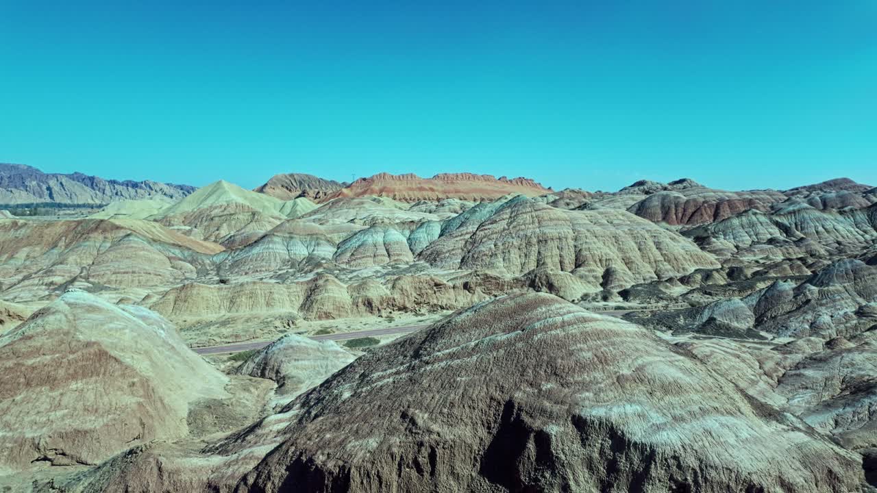 Zhangye, Gansu Province, China - The Striped, Rolling Hills Stretch Across the Dry Landscape Under a Clear Blue Sky - Pan Shot