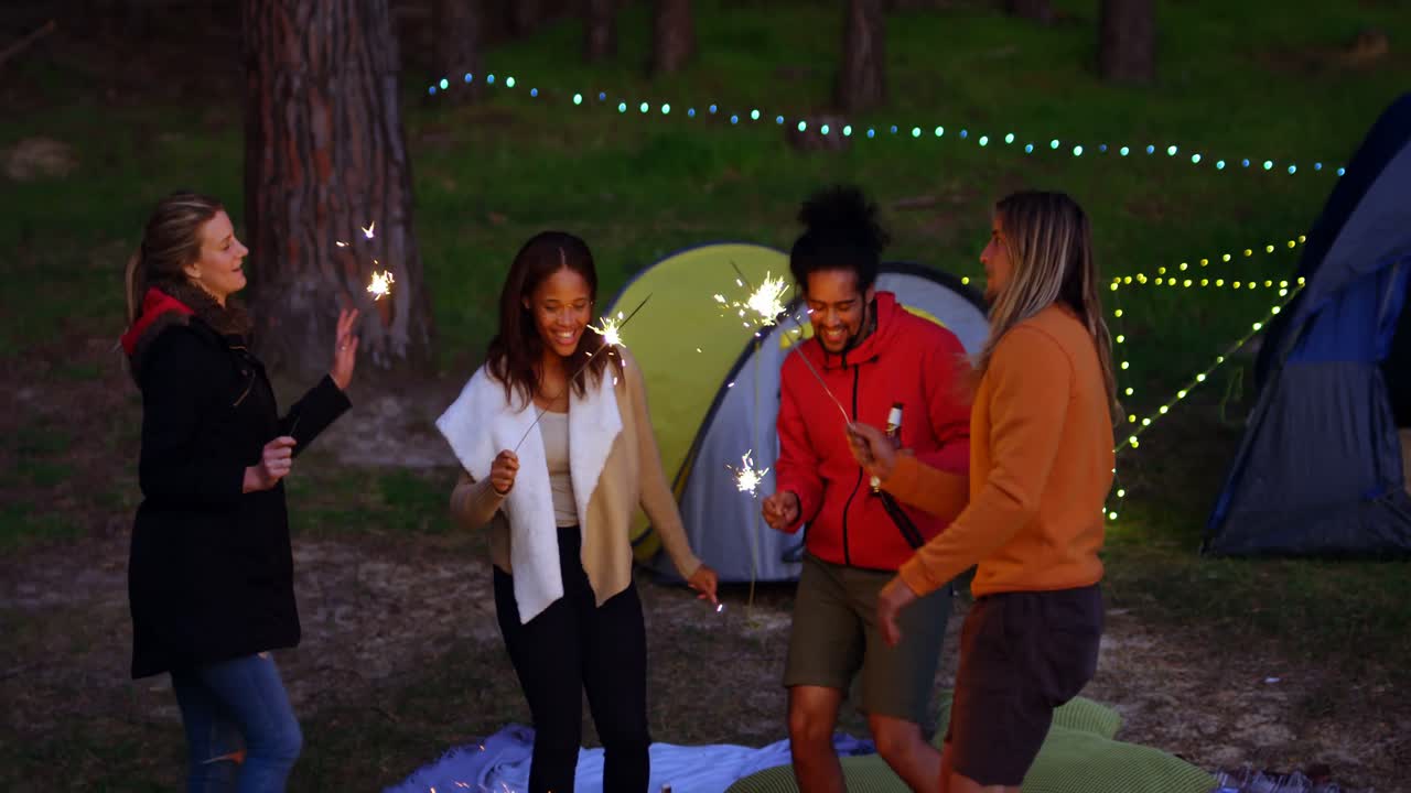 친구들이 숲에서 반 ⁇ 이는 불꽃으로 재미를 느끼고 있습니다.