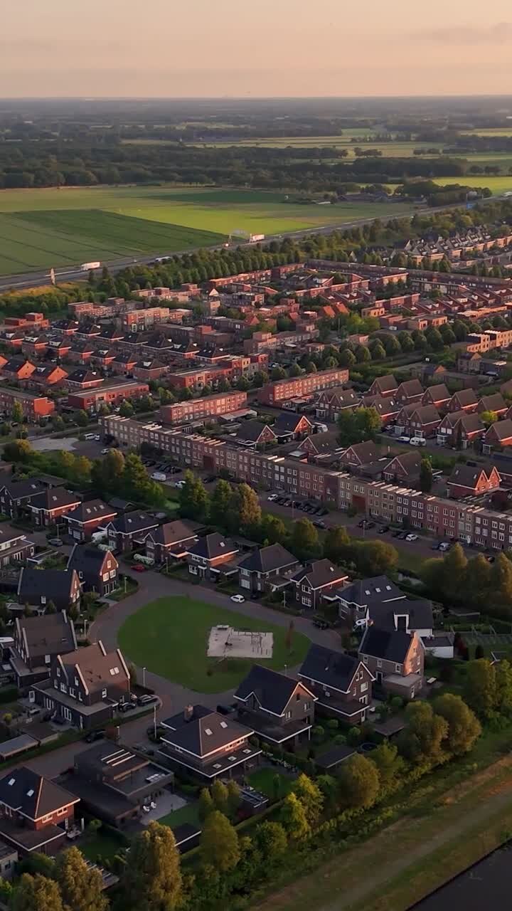 Vista aerea di un'area residenziale suburbana con case e campi verdi al tramonto