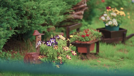 creatively arranged flowerpots with perennial flowers on the green lawn in the garden