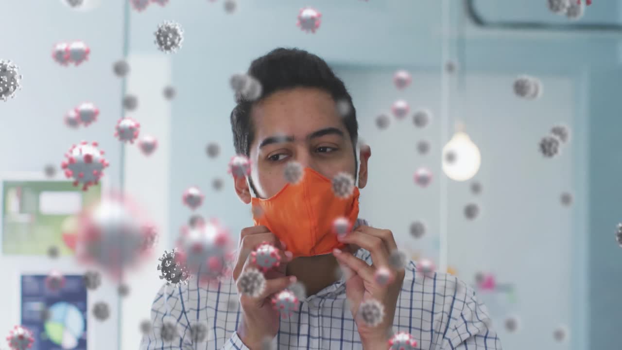 여러 코로나19 세포가 사무실에서 얼굴 마스크를 조정하는 남자를 향해 떠다니고 있습니다.