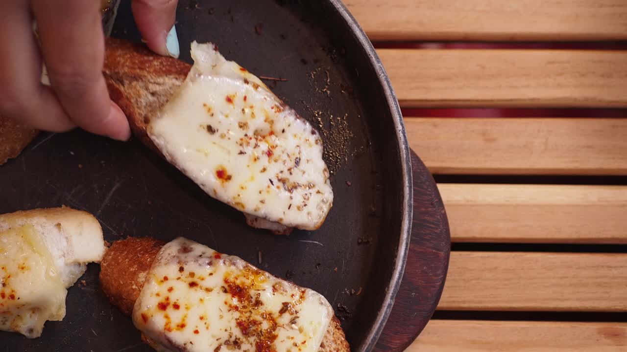 persona sosteniendo un pedazo de sándwich de queso a la parrilla