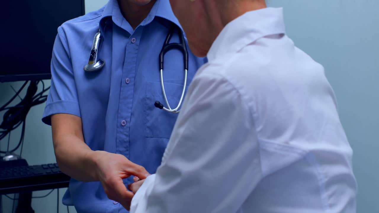 Young Asian male doctor examining a senior patient in the clinic 4k