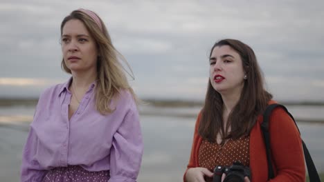 two women discussing photography in a natural setting