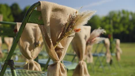 rustic wedding ceremony decor: burlap-wrapped chairs with dried flower arrangements