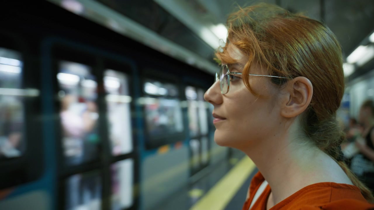 Una turista attende l'arrivo del treno della metropolitana a Napoli.
