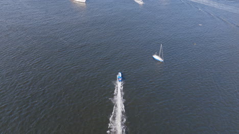 Aerial-footage,-following-a-speedboat-rushing-through-the-open-waters-of-Botafogo-Bay-in-Rio-de-Janeiro,-Brazil