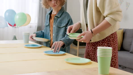 mujer y niño preparando la mesa