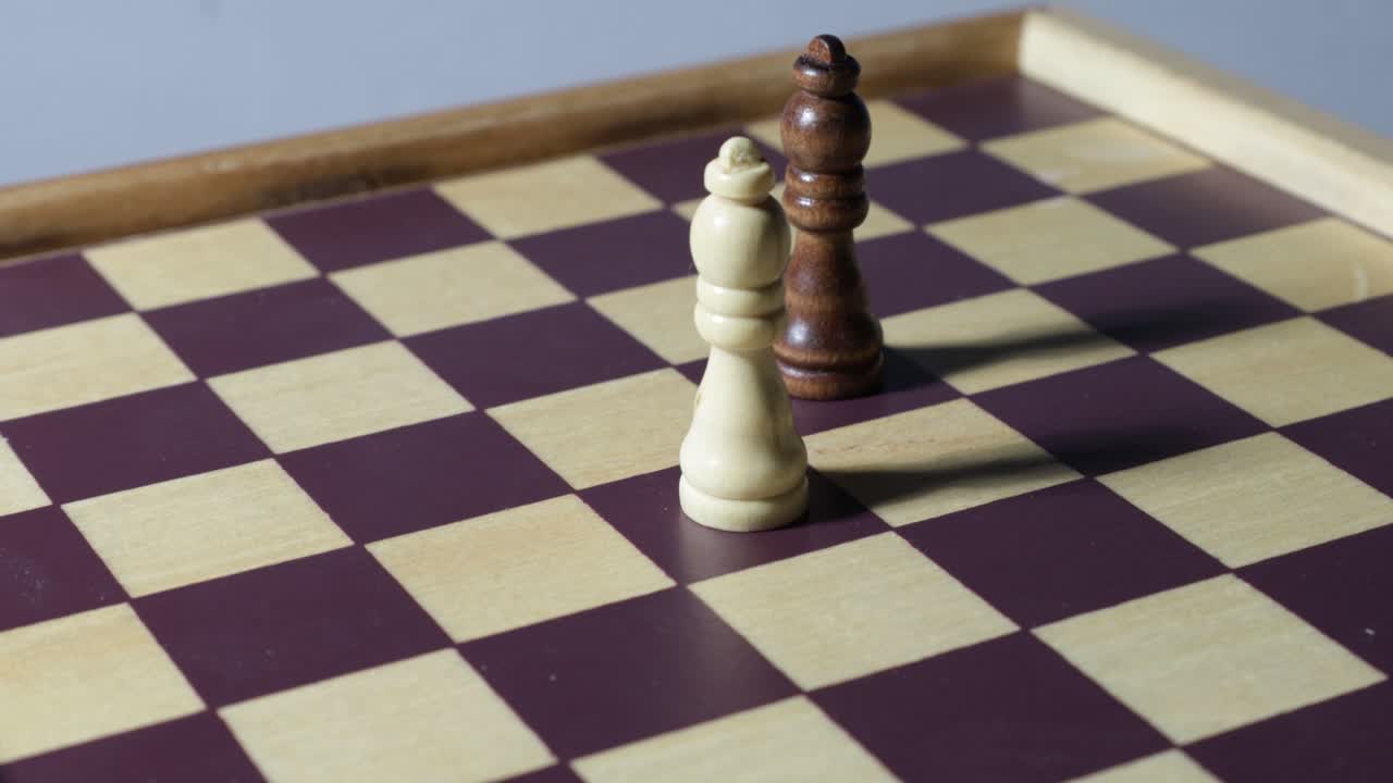 Rotating cinematic shot around two queens on a chessboard