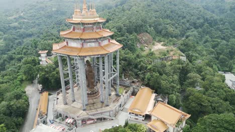 aerial of kek lok si temple penang island malaysia buddha scullpture close up drone fly above green vegetation jungle